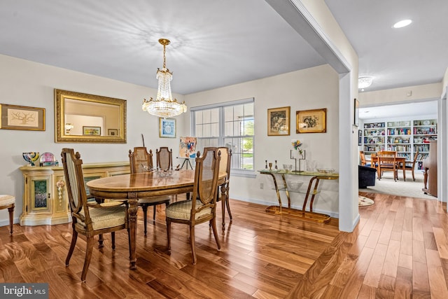 dining room with baseboards, recessed lighting, wood finished floors, and a notable chandelier