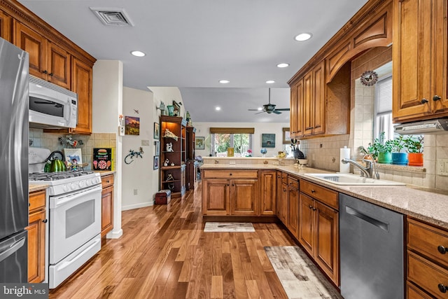 kitchen with a sink, stainless steel appliances, recessed lighting, decorative backsplash, and visible vents