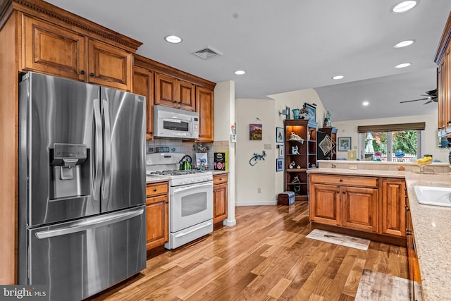 kitchen featuring decorative backsplash, visible vents, light wood finished floors, recessed lighting, and white appliances