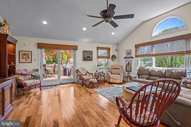 living room featuring light wood-style floors, plenty of natural light, a ceiling fan, and vaulted ceiling