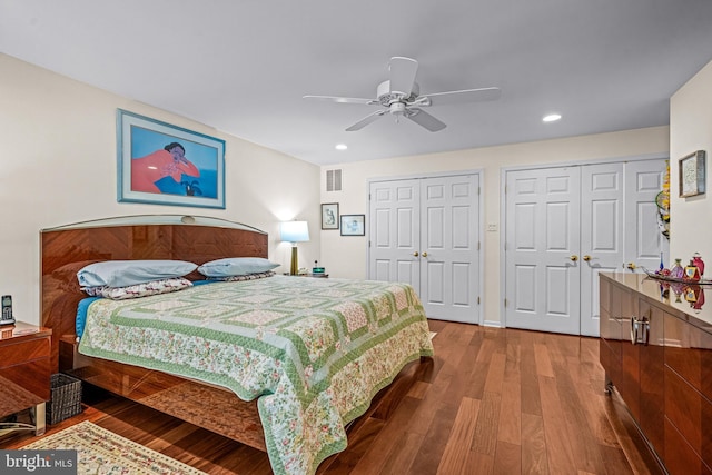 bedroom with visible vents, recessed lighting, two closets, and hardwood / wood-style flooring