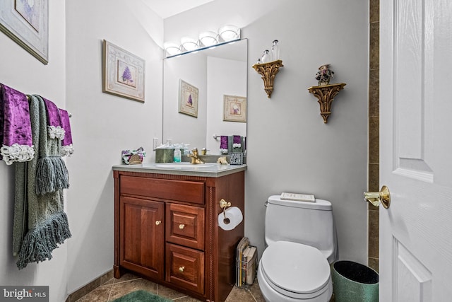 bathroom with toilet, tile patterned floors, and vanity