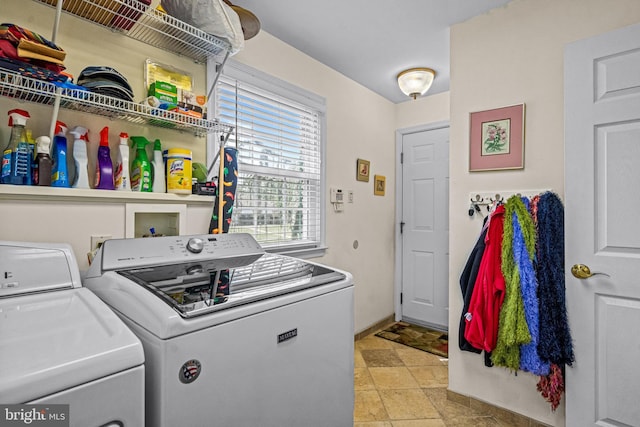 clothes washing area with laundry area, stone finish flooring, and washer and dryer