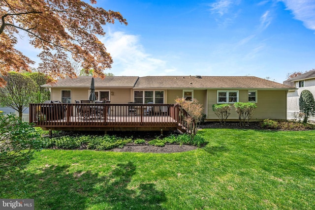 rear view of house with a lawn and a deck