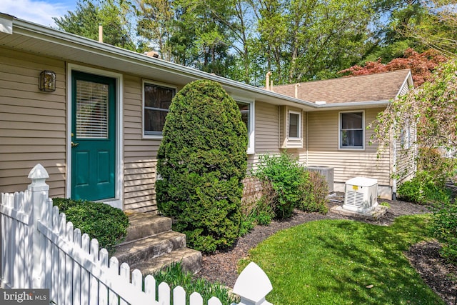 doorway to property featuring central AC and fence