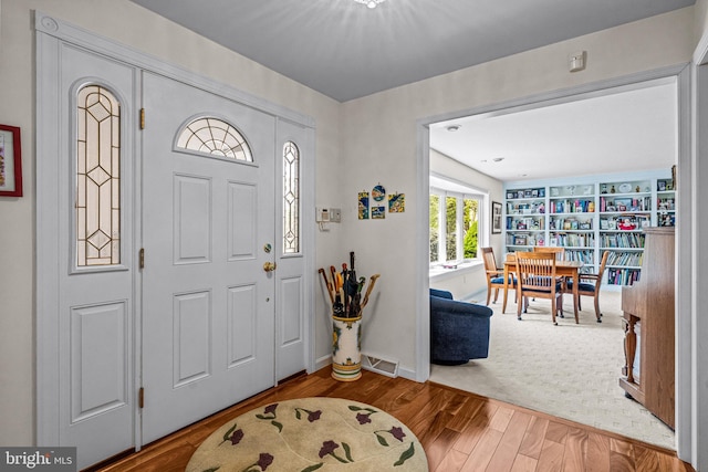 foyer with visible vents, baseboards, and wood finished floors
