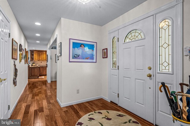 foyer entrance with recessed lighting, baseboards, and wood finished floors