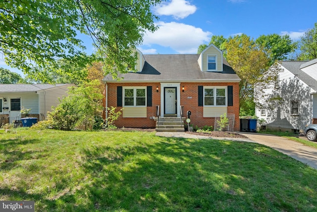 cape cod house with concrete driveway, brick siding, and a front yard