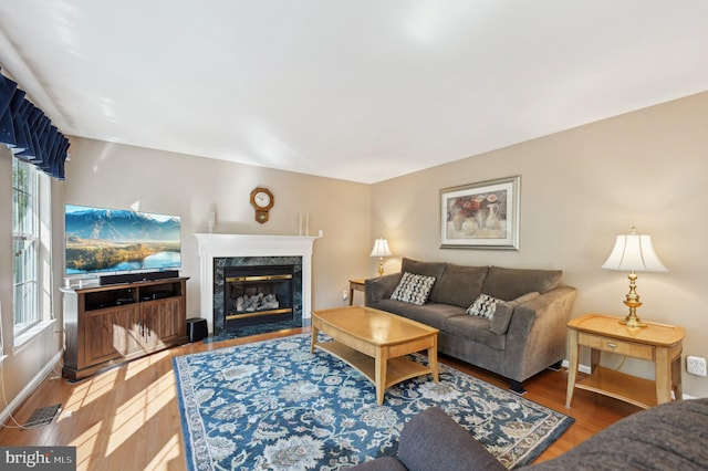 living room with a wealth of natural light, wood finished floors, and a fireplace