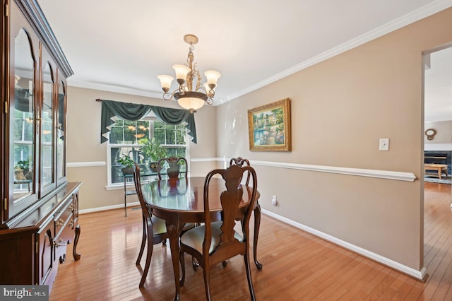 dining space with baseboards, a notable chandelier, and light wood-style flooring