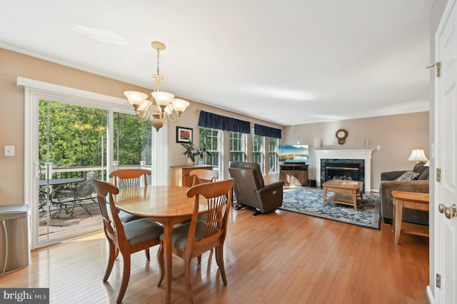 dining space featuring a healthy amount of sunlight, light wood-style floors, and a chandelier