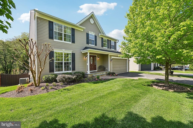 traditional-style house featuring a front lawn, aphalt driveway, fence, an attached garage, and central air condition unit