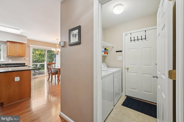 laundry room featuring laundry area, light wood finished floors, a chandelier, and washer and dryer