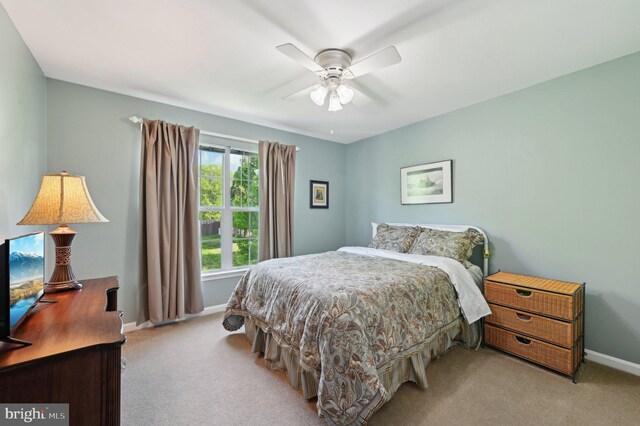 bedroom with baseboards, a ceiling fan, and light carpet