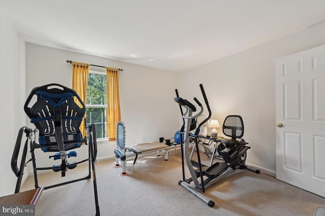 workout area featuring baseboards and carpet