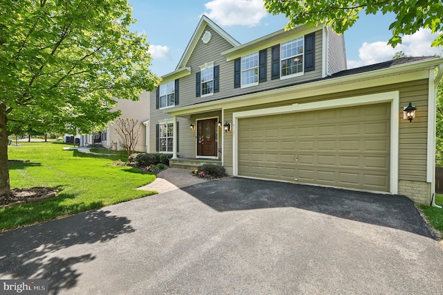 view of front of home featuring a garage, driveway, and a front yard