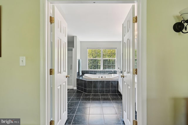 bathroom with a garden tub and tile patterned floors