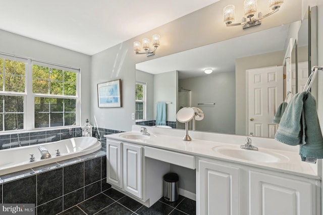 full bathroom featuring tile patterned flooring, a sink, a garden tub, and a chandelier