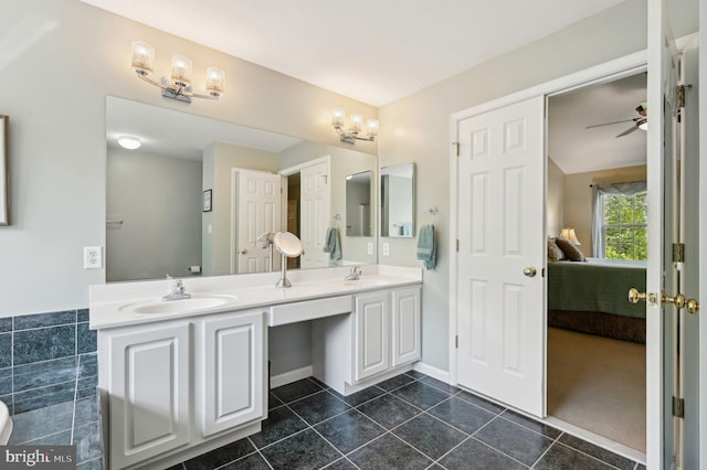 ensuite bathroom with a sink, tile patterned flooring, ensuite bathroom, and double vanity