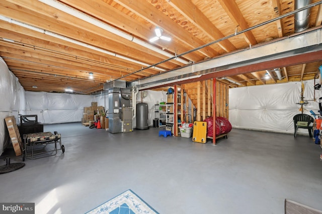 unfinished below grade area featuring heating unit and water heater