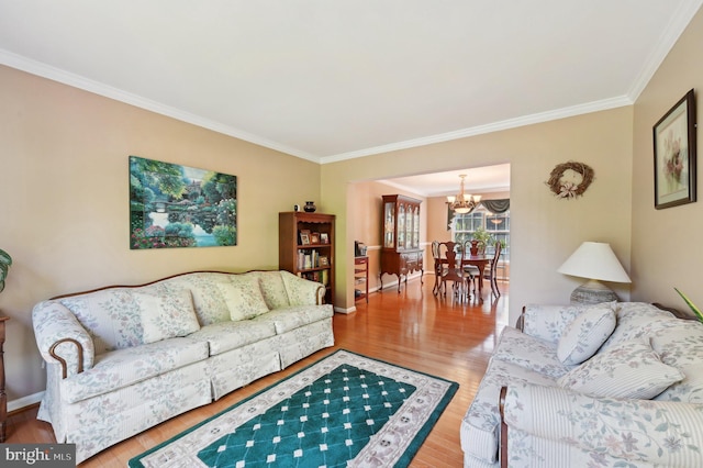 living area featuring crown molding, baseboards, an inviting chandelier, and wood finished floors