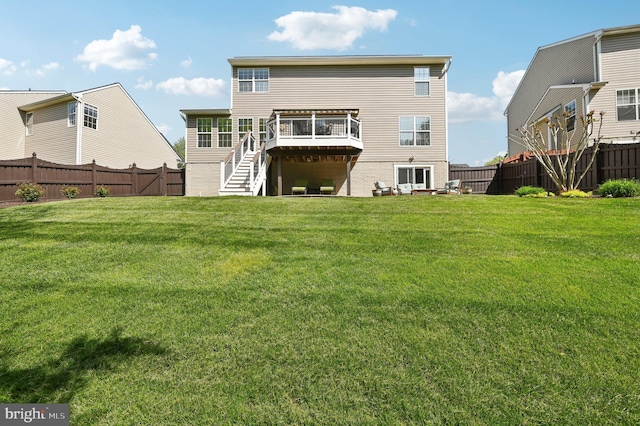 back of property featuring stairs, a fenced backyard, and a lawn