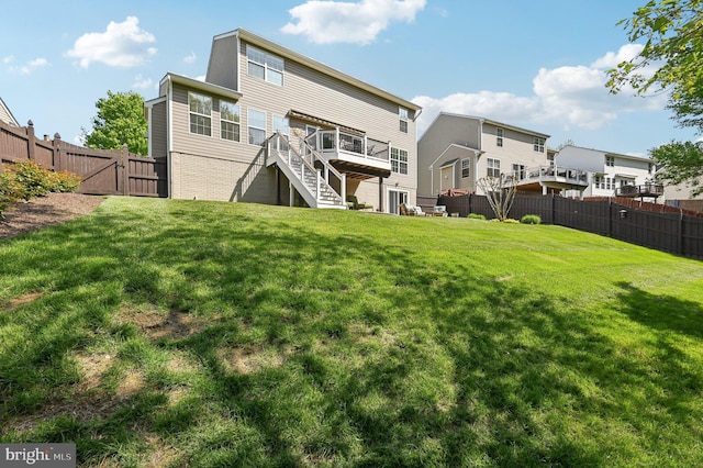 rear view of property featuring a fenced backyard, a gate, a wooden deck, and stairway
