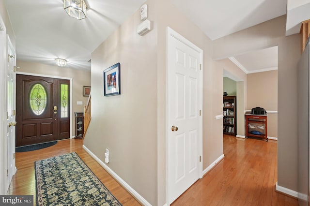 foyer with stairs, baseboards, and light wood-type flooring