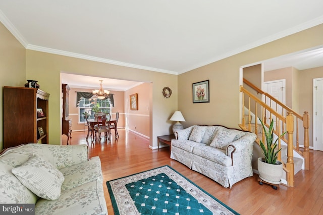 living room with ornamental molding, a notable chandelier, and wood finished floors