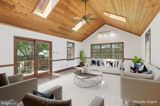 living area with high vaulted ceiling, ceiling fan, a skylight, and wooden ceiling