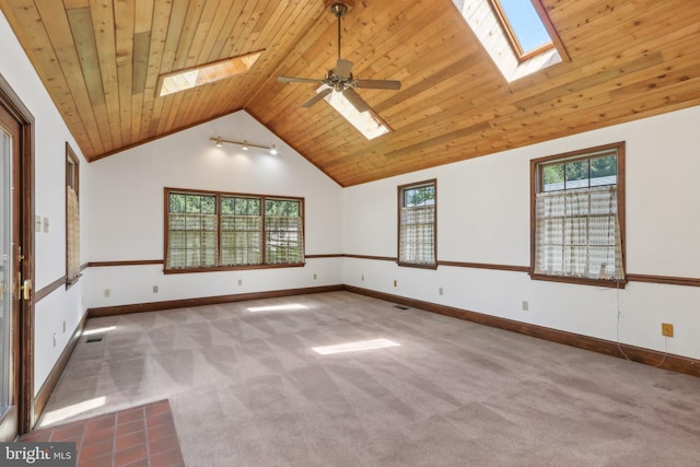 empty room with wood ceiling, ceiling fan, visible vents, lofted ceiling with skylight, and carpet flooring