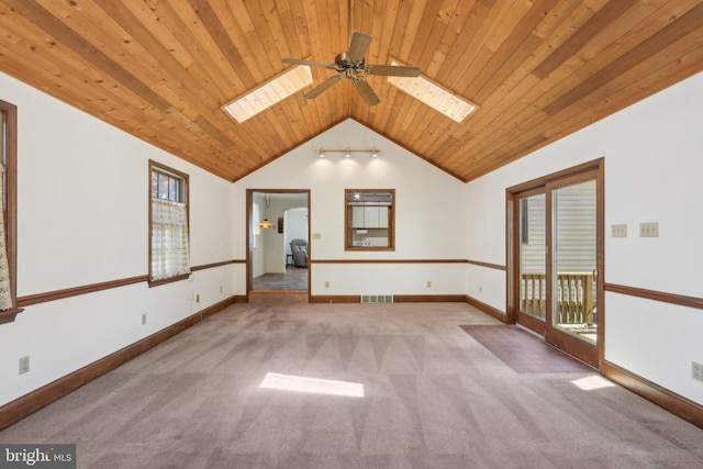 unfurnished room with visible vents, carpet flooring, lofted ceiling with skylight, wooden ceiling, and a ceiling fan