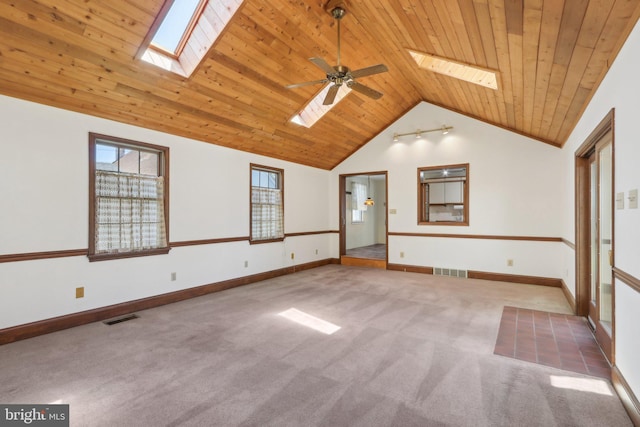 carpeted spare room featuring wooden ceiling, a ceiling fan, lofted ceiling with skylight, and visible vents