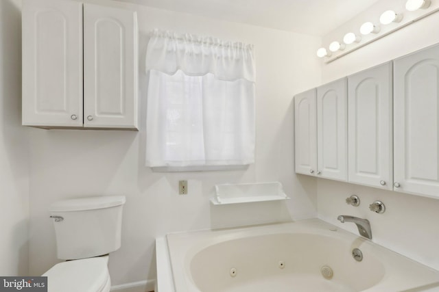 full bathroom with a tub with jets, baseboards, and toilet