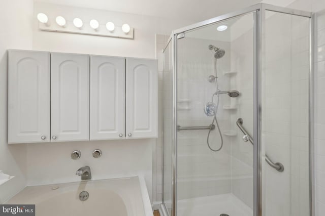 bathroom featuring a bath and a stall shower