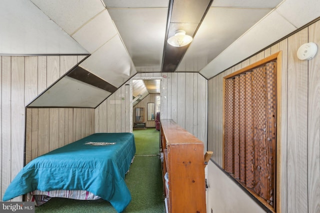 carpeted bedroom with wooden walls and lofted ceiling