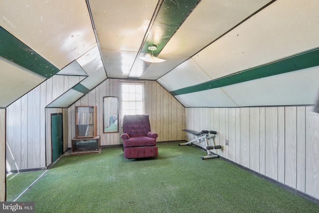 additional living space with carpet, vaulted ceiling, and wood walls