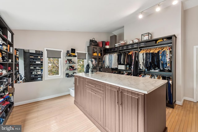 walk in closet with light wood-style flooring
