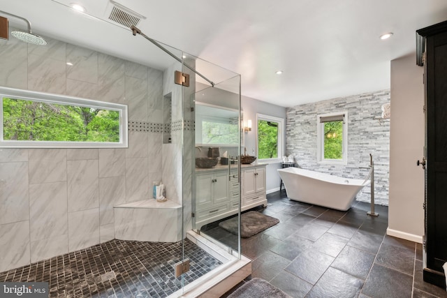 bathroom with a freestanding bath, a wealth of natural light, a shower stall, and vanity