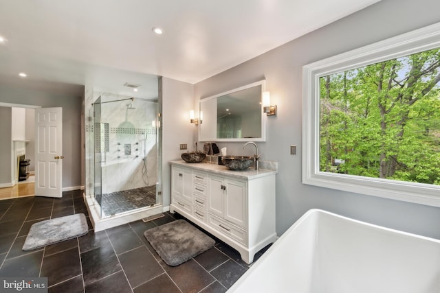 full bath featuring a shower stall, recessed lighting, vanity, and a freestanding tub