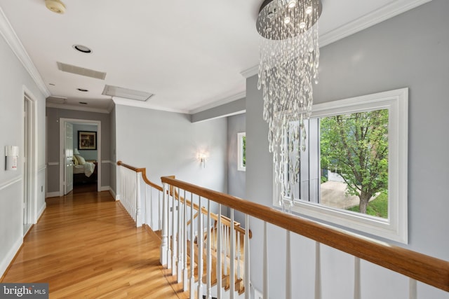hallway with crown molding, wood finished floors, an upstairs landing, and baseboards