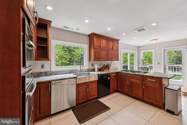 kitchen featuring a healthy amount of sunlight, visible vents, a sink, a peninsula, and stainless steel appliances