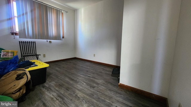unfurnished bedroom with dark wood-type flooring and baseboards