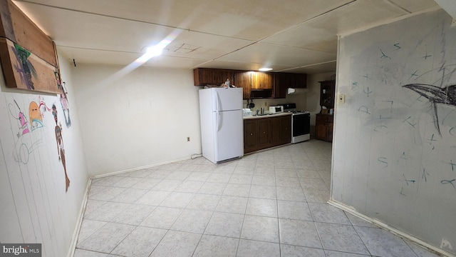 kitchen with white appliances, light countertops, dark brown cabinets, baseboards, and light tile patterned flooring