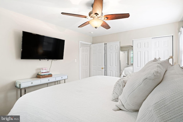 bedroom with a ceiling fan and multiple closets
