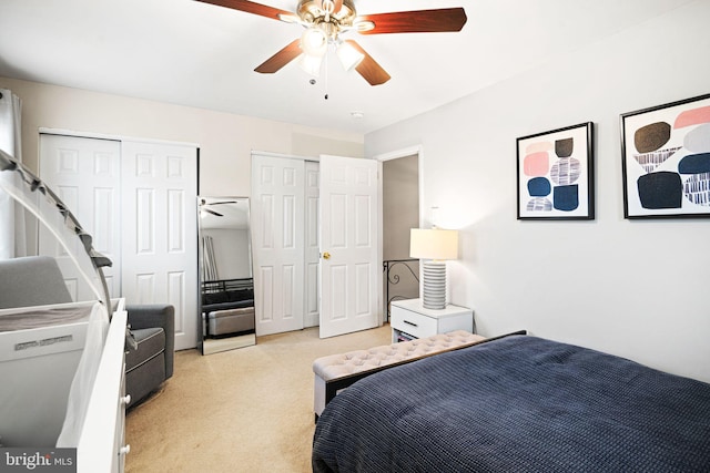 bedroom with multiple closets, ceiling fan, and light carpet
