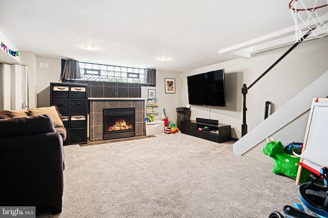 living area featuring a tiled fireplace and carpet