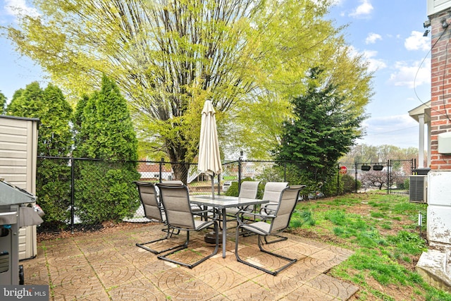 view of patio / terrace featuring central AC unit, outdoor dining space, and a fenced backyard