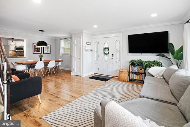 living room featuring recessed lighting, baseboards, ornamental molding, and light wood-type flooring