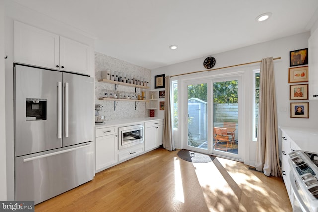 kitchen with light countertops, stainless steel appliances, light wood finished floors, and white cabinetry